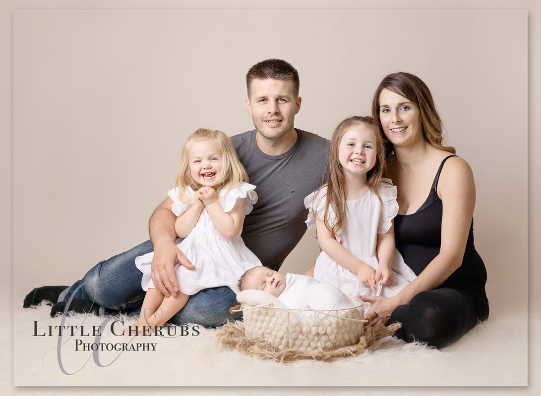 new family portrait professional photographer big sisters new baby boy first family photograph cambridge little cherubs photography 