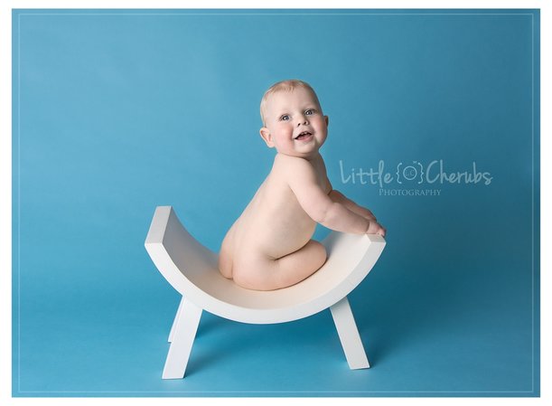 baby's first year sitting on stool on blue background at march photography studio