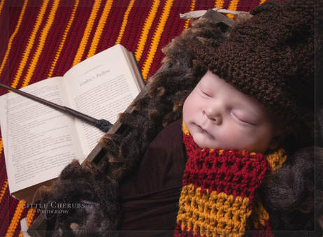 newborn baby asleep in witches hat next to harry potter book in gryffindor colours little cherubs photography cambridge peterborough