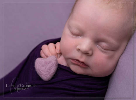 newborn baby girl in shades of purple with felted heart first photo shoot little cherubs photography studio cambridge huntingdon peterborough