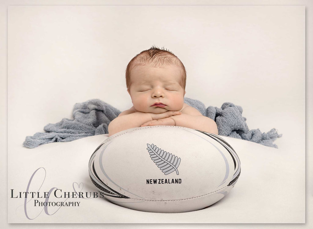 newborn baby asleep on rugby ball football cute sporting photography little cherubs peterborough cambridge ely photographer